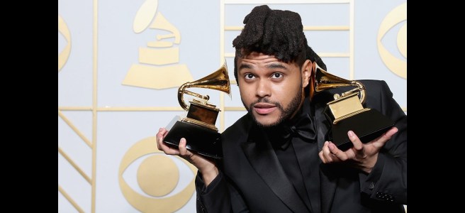 grammy winner holding trophies